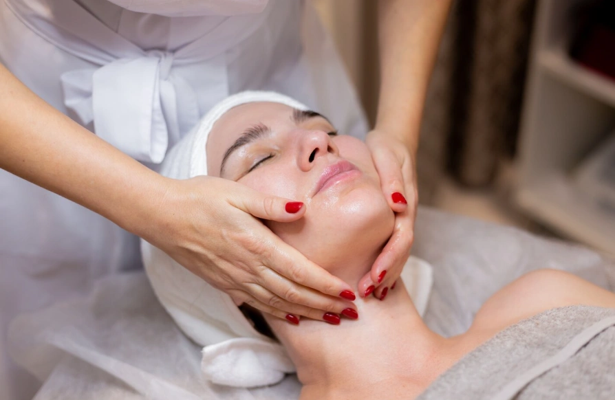 Esthetician giving a traditional facial massage during a treatment at Glow Up Studio