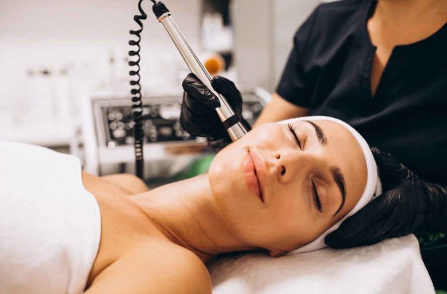 Esthetician performing a Hydrafacial Dallas treatment on a client's cheek at Glow Up Studio