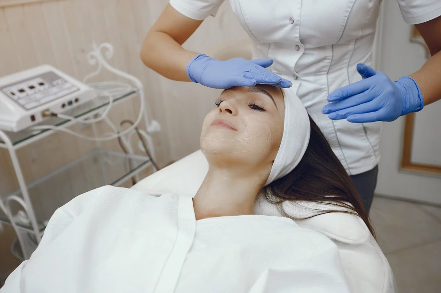 Esthetician performing a professional facial treatment at Glow Up Studio in Dallas