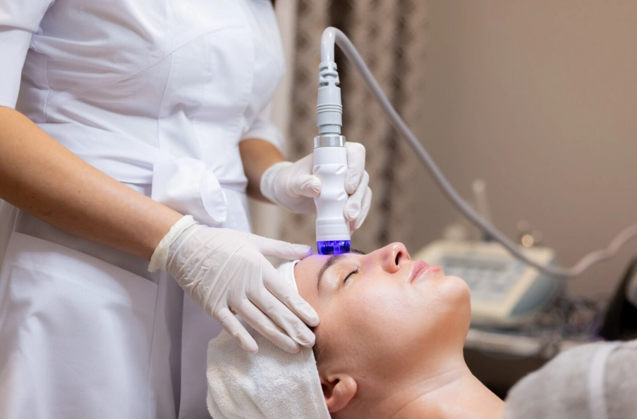 Hydrafacial Dallas treatment resurfacing a client's forehead at Glow Up Studio facial spa