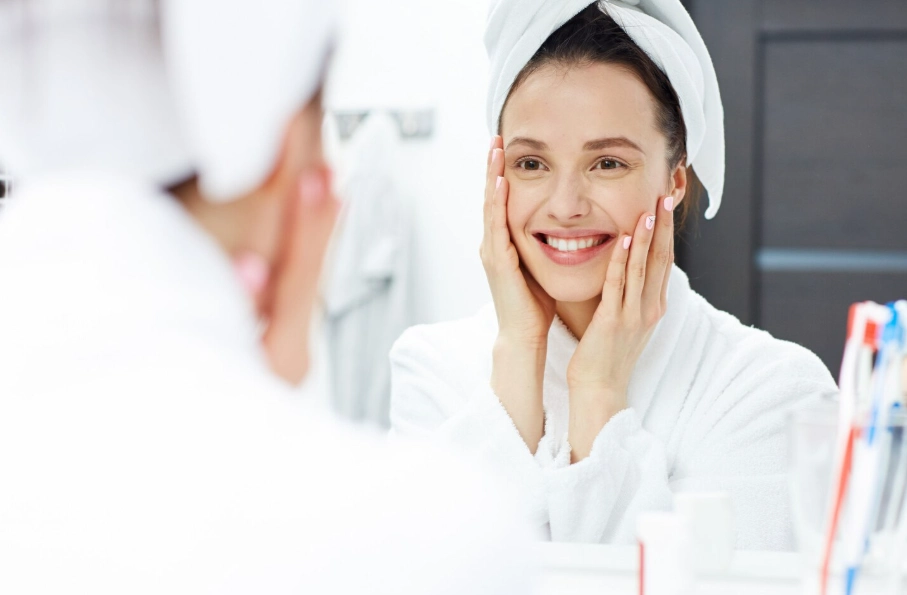 Woman with glowing skin comparing hydrafacial vs regular facial results at Glow Up Studio Dallas