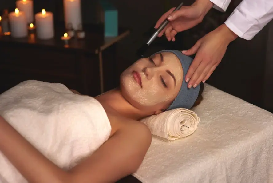 Client enjoying a candlelit mask treatment, a signature experience among the best facials in dallas for glowing skin