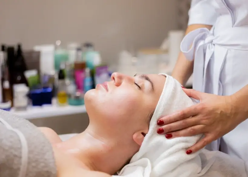 Relaxed client receiving a soothing head massage during one of the best facials in dallas at a professional skincare studio