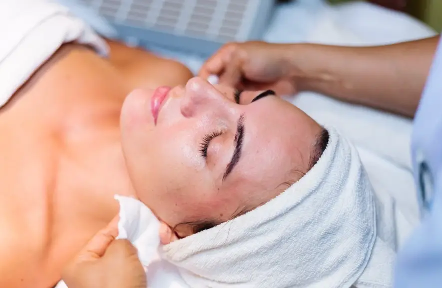 woman enjoying a professional facial at a Dallas spa while comparing chemical peel vs microdermabrasion for smooth glowing skin
